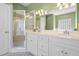 Bright bathroom with double sink vanity, glass shower, and tiled floors at 1111 Ole South Ct, Moncks Corner, SC 29461