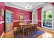 Elegant dining room with rich red walls, hardwood floors, and a chandelier, ideal for formal gatherings at 1111 Ole South Ct, Moncks Corner, SC 29461