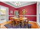 Charming dining room boasting cherry colored walls, classic wainscotting, and wood furniture at 1111 Ole South Ct, Moncks Corner, SC 29461