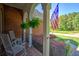 Relax on the covered front porch with comfortable white rocking chairs and hanging ferns at 1111 Ole South Ct, Moncks Corner, SC 29461