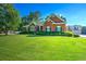 Quaint brick home with manicured lawn and beautiful landscaping. A private drive leads to a detached garage at 1111 Ole South Ct, Moncks Corner, SC 29461