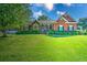 Charming single-story brick home with a manicured lawn, mature trees and neatly trimmed shrubbery at 1111 Ole South Ct, Moncks Corner, SC 29461