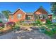 Brick home's rear exterior featuring a patio, well-kept backyard, and lush flowerbeds at 1111 Ole South Ct, Moncks Corner, SC 29461