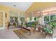 Charming sunroom with wicker seating, warm yellow walls, and abundant natural light flooding through large windows at 1111 Ole South Ct, Moncks Corner, SC 29461