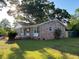 Charming brick home exterior with manicured lawn, mature trees, and covered porch at 121 Camelot Dr, Goose Creek, SC 29445