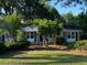 Inviting single-story home with brick accents, a covered porch, and mature landscaping at 121 Camelot Dr, Goose Creek, SC 29445