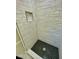 Walk-in shower featuring black honeycomb tile floor, white subway tile, and built in shelf at 121 Camelot Dr, Goose Creek, SC 29445