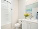 Bright bathroom with a shower-tub combo, and a white vanity with a decorative mirror and fresh flowers at 121 Cherry Grove, Summerville, SC 29483