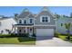 Charming two-story home boasts a mix of stone and siding, enhanced by a lush green lawn and twilight sky at 121 Cherry Grove, Summerville, SC 29483