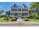 A beautiful two-story home with a metal roof, a welcoming porch, and vibrant flower beds lining the walkway at 121 Cherry Grove, Summerville, SC 29483