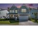 Charming two-story home boasts a mix of stone and siding, enhanced by a lush green lawn and twilight sky at 121 Cherry Grove, Summerville, SC 29483