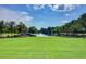 Expansive green space with manicured lawn leading to a picturesque pond with fountain and mature trees at 121 Cherry Grove, Summerville, SC 29483
