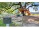 A wooden treehouse with slides and stairs is set amongst a large oak, offering a unique recreational space at 121 Cherry Grove, Summerville, SC 29483