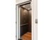 Interior view of an elevator featuring wood floors, brown wallpaper, and a metal hand rail at 122 Beaufain St # C, Charleston, SC 29401