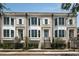 Charming brick townhomes feature bay windows, white shutters, black iron fencing, and manicured landscaping at 122 Beaufain St # C, Charleston, SC 29401