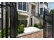 Brick townhouse entrance with an iron gate, stone steps, and beautifully landscaped yard at 122 Beaufain St # C, Charleston, SC 29401