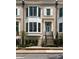 Charming brick townhome featuring a bay window, black iron fence, and manicured landscaping at 122 Beaufain St # C, Charleston, SC 29401