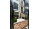 Brick townhouse entrance with an iron gate, stone steps, and beautifully landscaped yard at 122 Beaufain St # C, Charleston, SC 29401