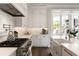 Close up of the modern kitchen featuring a gas range, white cabinets, and marble countertops at 122 Beaufain St # C, Charleston, SC 29401