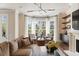 Bright living room with a bay window, two chairs, a sofa, hardwood floors, and custom shelving at 122 Beaufain St # C, Charleston, SC 29401