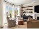 Comfortable living room with a bay window, chairs, hardwood floors, shelving, and a fireplace at 122 Beaufain St # C, Charleston, SC 29401