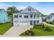 Beautiful two-story home with a well-manicured lawn, lush landscaping, and a three-car garage at 1234 Captain Rivers Dr, Charleston, SC 29412