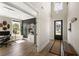 Bright foyer boasts wood floors, a modern chandelier, and a clear view of a home office flooded with natural light at 1234 Captain Rivers Dr, Charleston, SC 29412