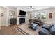 Stylish living room with a fireplace, large windows, modern furniture, and hardwood floors at 1234 Captain Rivers Dr, Charleston, SC 29412