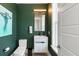 This modern powder room features a vibrant green wall, vanity with sink, a sleek faucet and a mirror at 1234 Captain Rivers Dr, Charleston, SC 29412