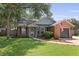 Charming brick home with manicured lawn, mature trees, and American flag at 1308 Cadet Ct, Mount Pleasant, SC 29466