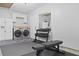 A well-lit laundry room with washer, dryer, storage, and workout equipment at 1308 Cadet Ct, Mount Pleasant, SC 29466