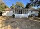 Home's white brick back exterior features a screened-in porch and a well-kept, expansive yard at 1329 Camp Rd, Charleston, SC 29412