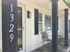 Inviting front porch of a charming house with white brick and black accents at 1329 Camp Rd, Charleston, SC 29412