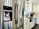 Close up of refrigerator and sink with white cabinets and brick backsplash at 1329 Camp Rd, Charleston, SC 29412