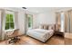 Bright bedroom features a king-sized bed, wood floors and three large windows that offer a verdant view at 1474 Blue Cascade Dr, Mount Pleasant, SC 29464