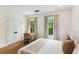 Bright bedroom features a king-sized bed, wood floors and three large windows that offer a verdant view at 1474 Blue Cascade Dr, Mount Pleasant, SC 29464