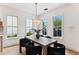 Bright dining room with large windows offering views of the outdoors, hardwood floors and contemporary chandelier at 1474 Blue Cascade Dr, Mount Pleasant, SC 29464
