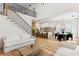 Open-concept living space with hardwood floors, modern staircase, and view into the kitchen at 1474 Blue Cascade Dr, Mount Pleasant, SC 29464