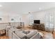 Bright and airy living room featuring a large couch, hardwood floors, and natural light from shuttered windows at 1474 Blue Cascade Dr, Mount Pleasant, SC 29464
