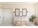 Bright and spacious bathroom with a double sink vanity, frameless glass shower, and decorative sconce lighting at 2046 Mcguire Ln # 012, Hollywood, SC 29449
