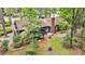 Aerial view showcasing a home with dark siding, a brick chimney, and mature trees at 205 Woodlawn St, Walterboro, SC 29488