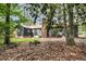 Beautiful backyard featuring lush greenery, mature trees, and a charming home exterior with a brick chimney at 205 Woodlawn St, Walterboro, SC 29488