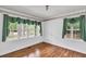 Bright, empty bedroom with hardwood floors and large windows framed by decorative curtains at 205 Woodlawn St, Walterboro, SC 29488