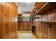 View of walk-in closet with wooden walls and storage shelving units at 205 Woodlawn St, Walterboro, SC 29488