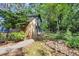 Exterior view with lush greenery and a mix of natural wood and charcoal grey, offering privacy and charm at 205 Woodlawn St, Walterboro, SC 29488