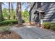 Home's covered entrance and partial view of walkway, with shingle siding and surrounded by trees at 205 Woodlawn St, Walterboro, SC 29488