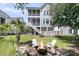 Relaxing backyard features a fire pit, Adirondack chairs, and a spacious lawn at 2072 Amenity Park Dr, Mount Pleasant, SC 29466