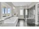 Bright bathroom showcasing a bathtub, large window, glass door shower and vanity with a sink at 2072 Amenity Park Dr, Mount Pleasant, SC 29466