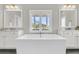 Bright bathroom featuring a freestanding tub with a window view and double vanity sinks with mirrors at 2072 Amenity Park Dr, Mount Pleasant, SC 29466