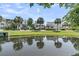 Beautiful view of the home reflected in the pond with lush greenery and palm trees in the foreground at 2072 Amenity Park Dr, Mount Pleasant, SC 29466